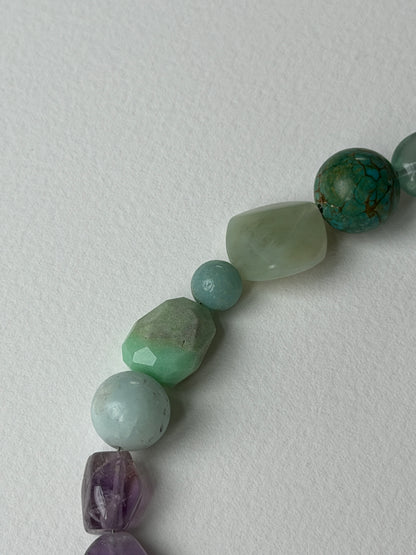 Meridian necklace close-up of green and amethyst stone beads